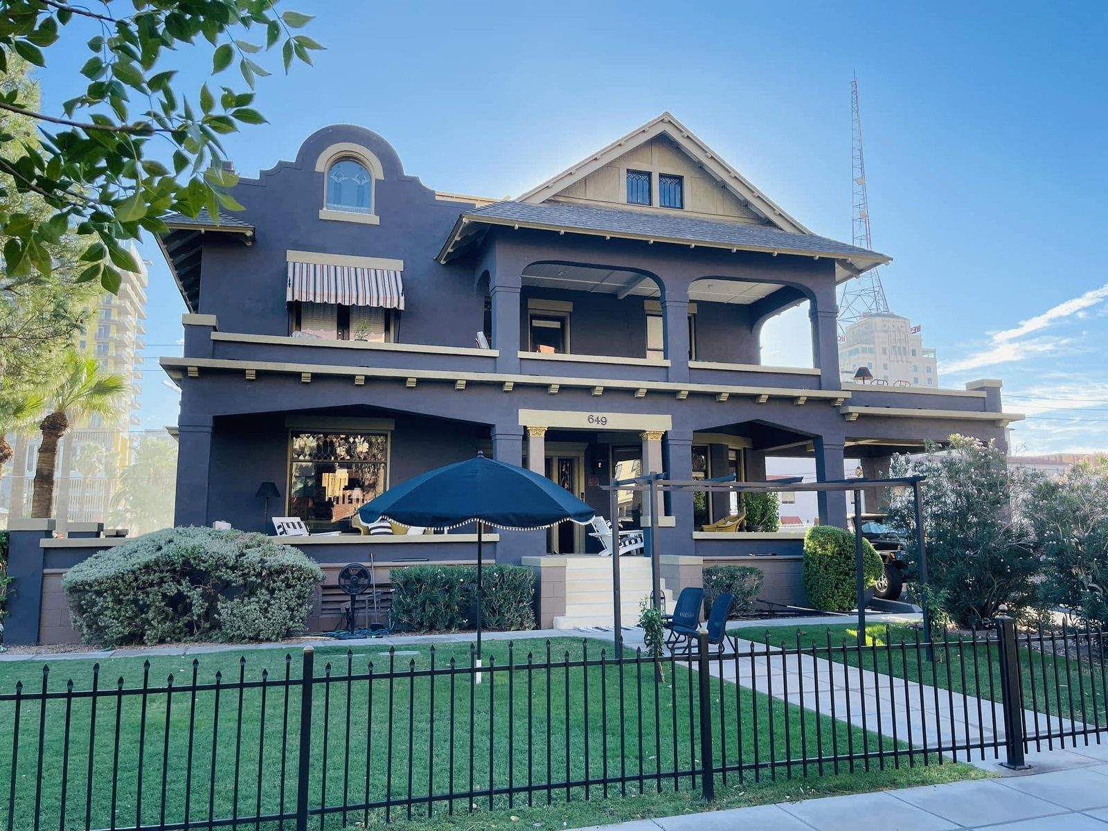 The DeMund House at 649 N 2nd Avenue: a two-story stucco house with a curved Mission parapet, a Craftsman gable, deep double porches and an iron fence