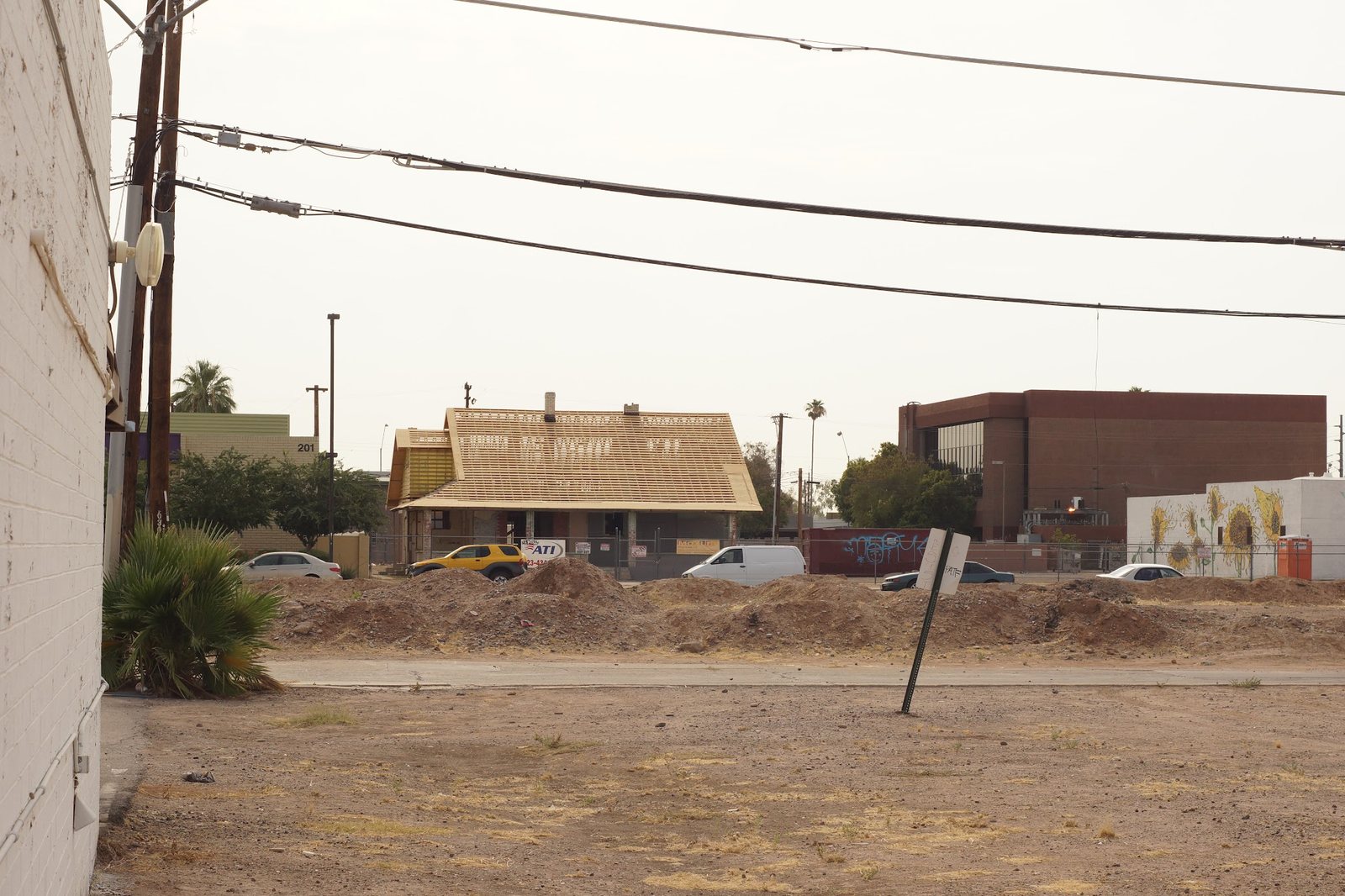 A vacant lot on Roosevelt Row in 2013, with an older house and new buildings beyond